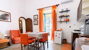 A compact living space with a dining area, kitchen, and a small balcony. - Casa Lucia  (Positano)