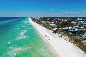 A coastal town with a long sandy beach, a pier, and buildings along the shore. - 3bd 2 bth condo in SRB Beach access 10 min walk to beach. Pool and fitness cntr (Santa Rosa Beach)
