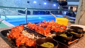 Un buffet proposant des plats de viande grillée sur brochettes et de petits bols de sauces.