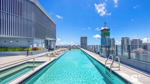 A rooftop pool with clear blue water, surrounded by modern buildings and a city skyline. - High-Rise Miami Condo | Rooftop Pool | Sea View (Miami)