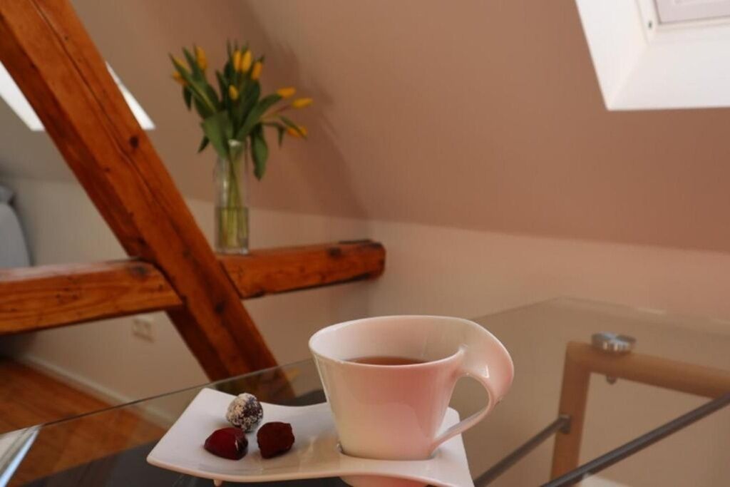 Ein Glastisch mit einer weißen Tasse und einem Teller mit Essen.