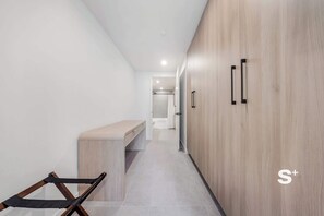 A narrow hallway with a bench, wooden wardrobe, and a shower area. - Rooftop Pool Oasis in Downtown Miami Condo w/ Gym (Miami)