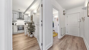A modern kitchen with white cabinets, a built-in oven, and a potted plant. - Prime Liverpool Street Retreat (London)