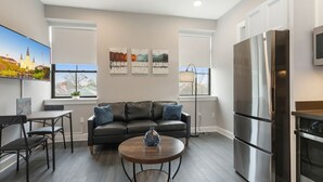 A modern living room with a sofa, coffee table, and artwork on the wall. - Charming 2BR Suite in Historic New Orleans (New Orleans)