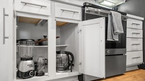 Uma cozinha com forno embutido, máquina de café e liquidificador.