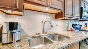 A kitchen with granite countertops, stainless steel appliances, and wooden cabinets. - NEW, Spacious 2 BR,Short Walk to the Beach,Private (Myrtle Beach)