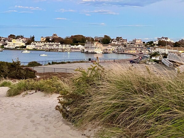 Eine Küstenstadt mit einem Yachthafen, Sandstrand und Wohngebäuden.