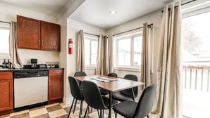 A compact kitchen with a dishwasher, a coffee machine, and a table with four chairs. - Charming 2 Bed, 1 Bath Escape | Free Parking, WiFi (Greater Sudbury)