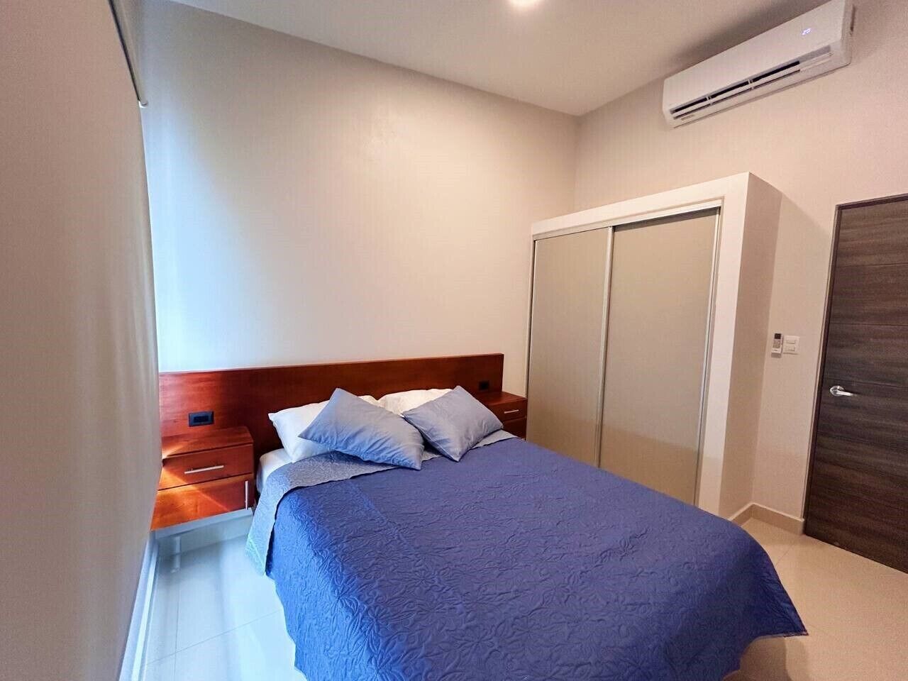 Una camera da letto con un letto, un comodino, un armadio e un condizionatore.