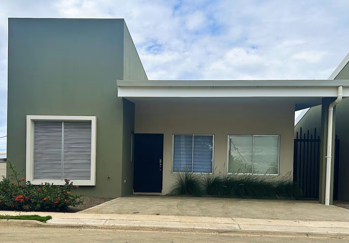 A modern two-story house with a garage, a front door, and a large window.