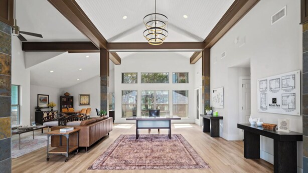 A spacious living area with a wooden floor, a central coffee table, and a seating area with sofas and chairs. - Relaxing King Suite Getaway | Sleeps 4 | Pool, Pkg (Austin)