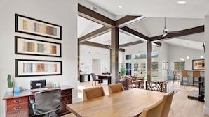 A spacious conference room with a long wooden table, comfortable chairs, and a modern office setup with a laptop and desk. - Relaxing King Suite Getaway | Sleeps 4 | Pool, Pkg (Austin)