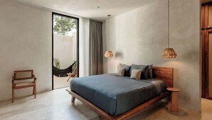 Une chambre moderne avec un grand lit, un hamac et une vue sur l’extérieur.