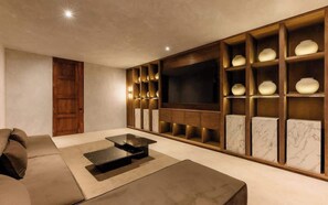 Ein modernes Wohnzimmer mit einer Couch, einem Couchtisch, einem Fernseher und einer Einbauschränke mit Dekorationselementen.