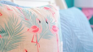 A close-up of a bed with a floral pillow and a blue blanket. - Flamingo Inn - Standard King with Kitchenette (Fort Myers Beach)
