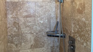 A shower with a handheld showerhead and a wall-mounted rain showerhead, set in a room with tiled walls. - Flamingo Inn - Standard King with Kitchenette (Fort Myers Beach)