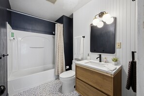A bathroom with a bathtub, toilet, vanity with a mirror, and a shower curtain. - 3 Private Apts in Tremont - Perfect for Groups (Cleveland)