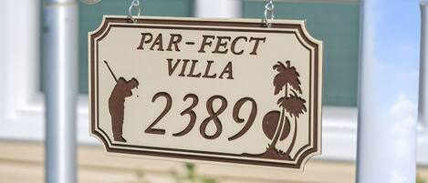 A sign for 'PAR-FACT VILLA 2389' with a silhouette of a golfer and palm trees.