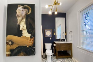 A bathroom with a large painting of a goat, a modern sink, and a patterned floor. - The Forsyth Victorian Gathering House - Sleeps 19! (Savannah)