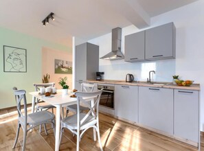 A modern kitchen with white cabinets, a built-in oven, and a coffee maker. - Apartment Zanet - Duplex Apartment with Sea View (Fazana)