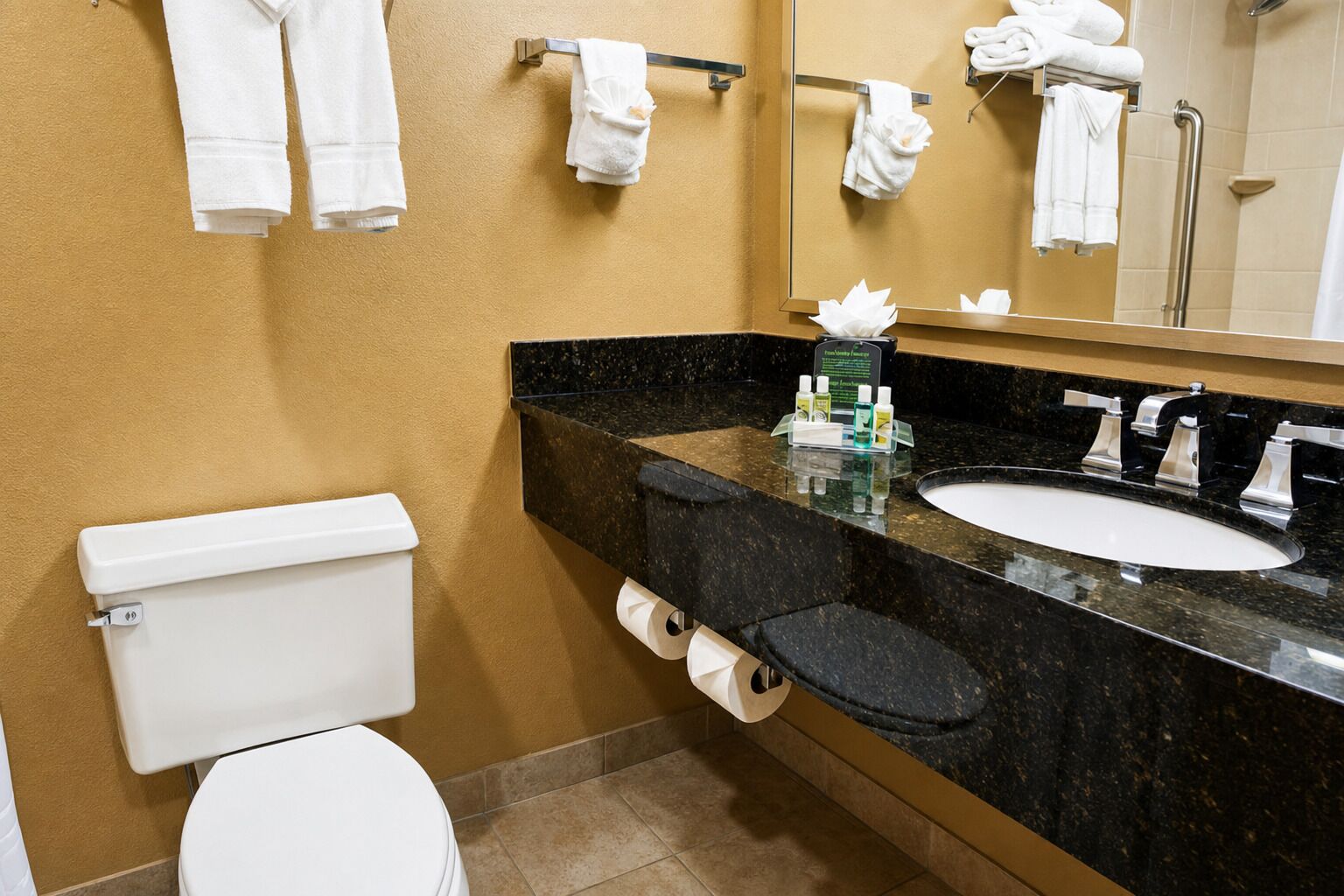Un baño con inodoro, lavamanos y toallero.