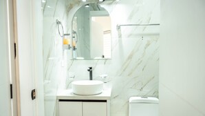A modern bathroom with a marble sink, a mirror, and a toilet. - Cozy Suite in the Heart of Historic Cuenca awaits you (Cuenca)
