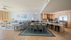 Een moderne woonkamer met een bank, salontafel en een eetgedeelte met stoelen en een tafel.