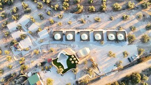 An aerial view of a resort with multiple cabins, a swimming pool, and a parking area.