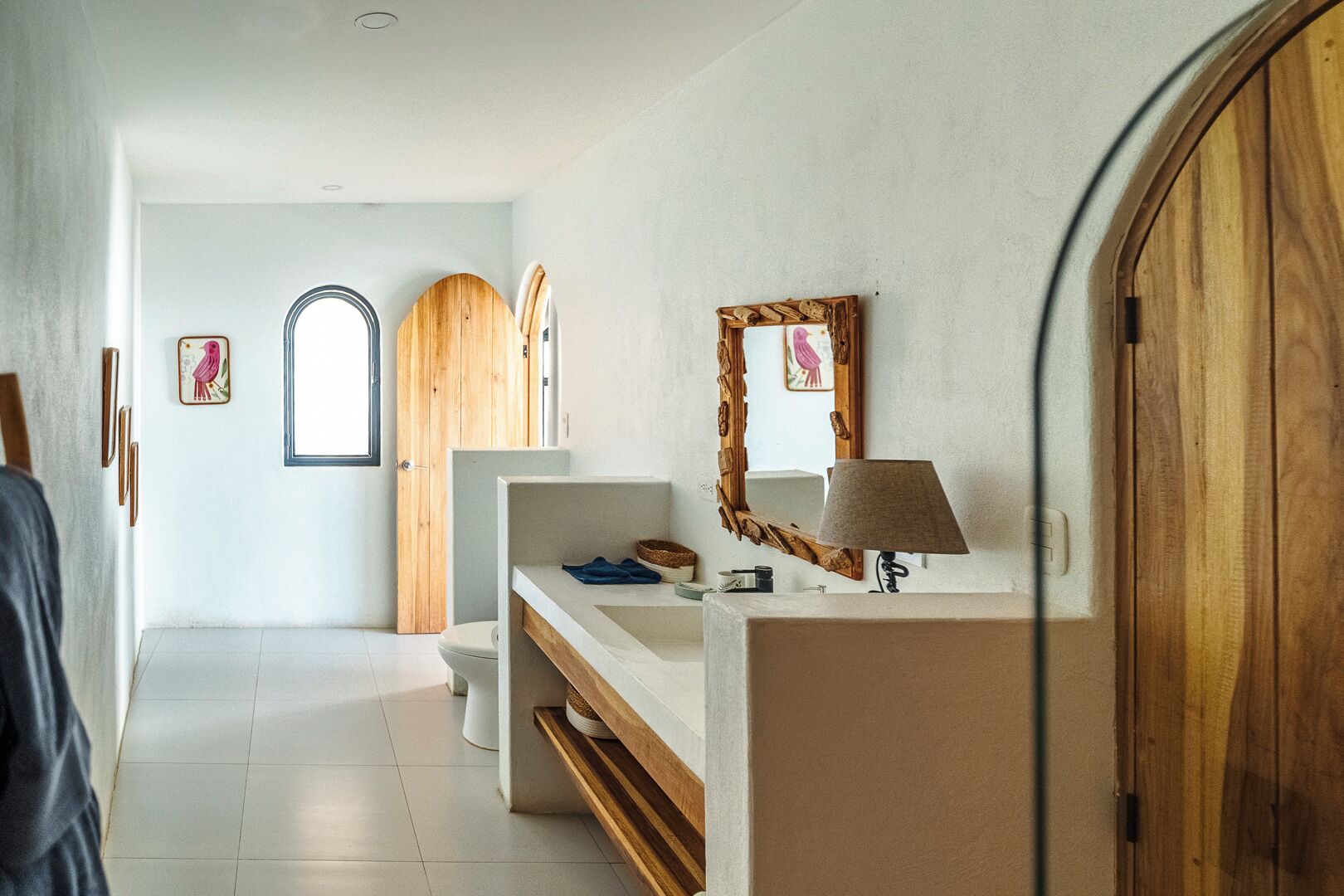 Un baño con tocador de madera, un espejo y un perchero para toallas.