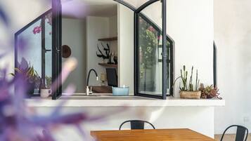 A modern kitchen with a large window, a sink, and a wooden table.