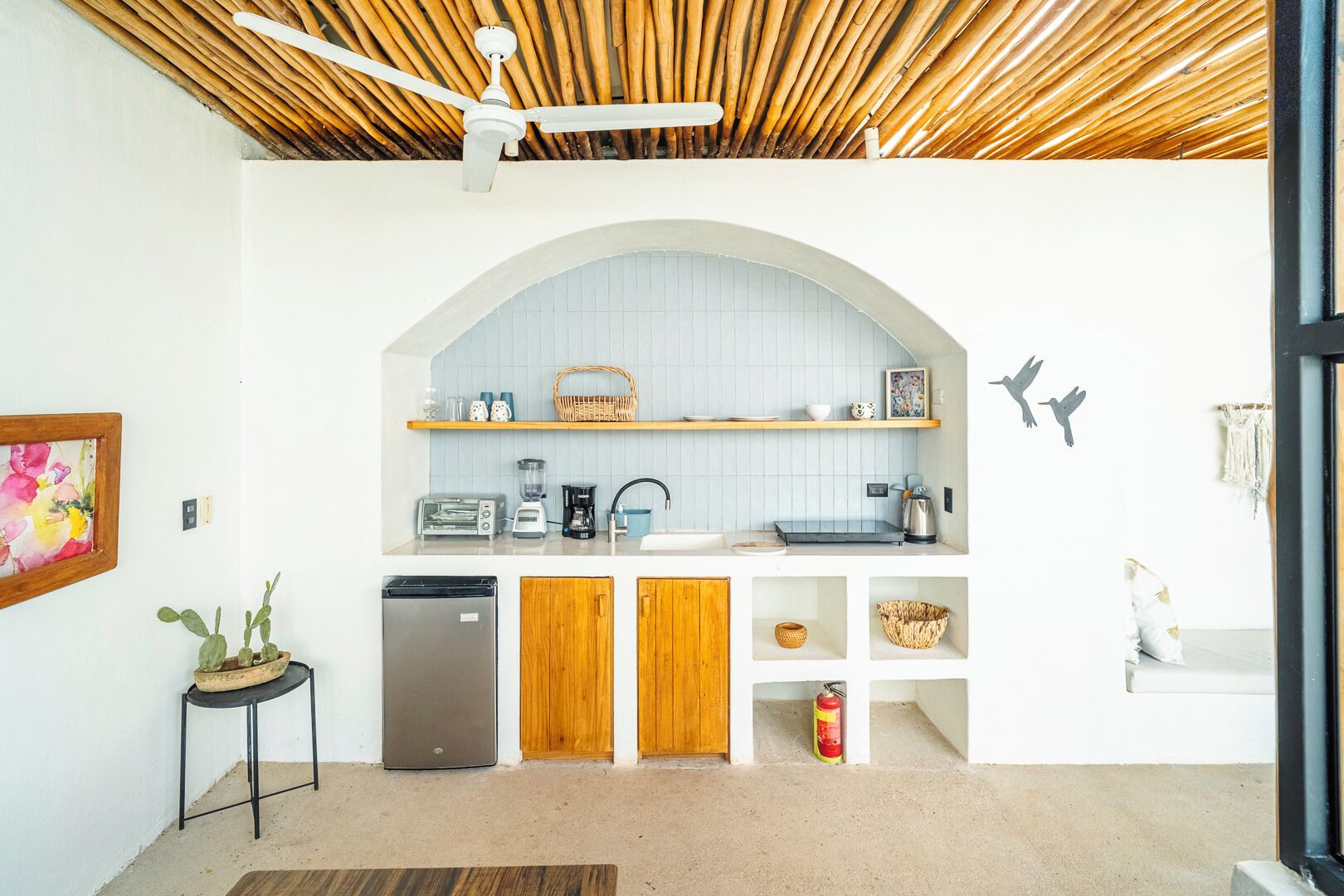 Una cocina compacta con horno integrado, cafetera y tostadora.