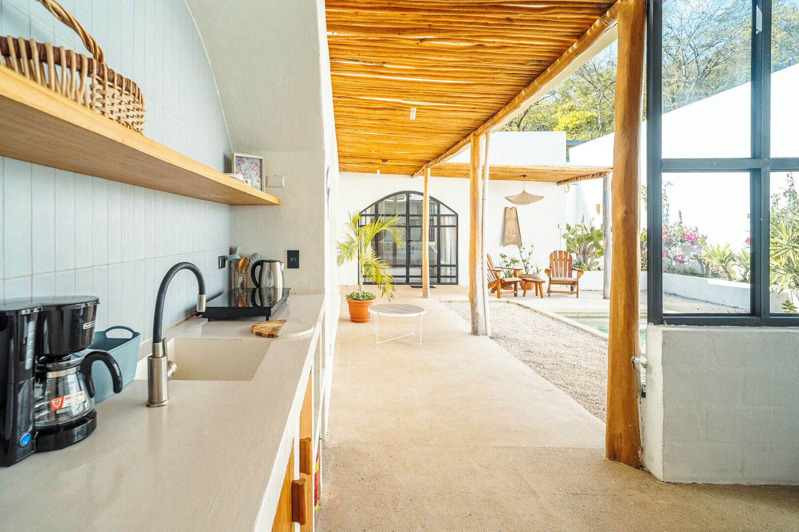 Una cocina moderna con cafetera, hervidor y estantes de madera.