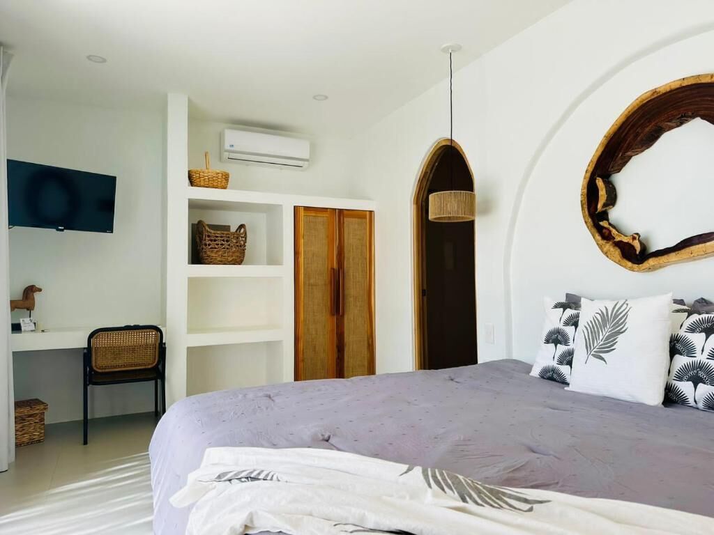 Une chambre à coucher comprenant un lit, un bureau, une chaise, une télévision et une armoire.