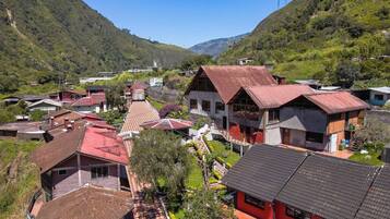 Un village doté de maisons traditionnelles, d’un bâtiment central coiffé d’un toit rouge et entouré de verdure.