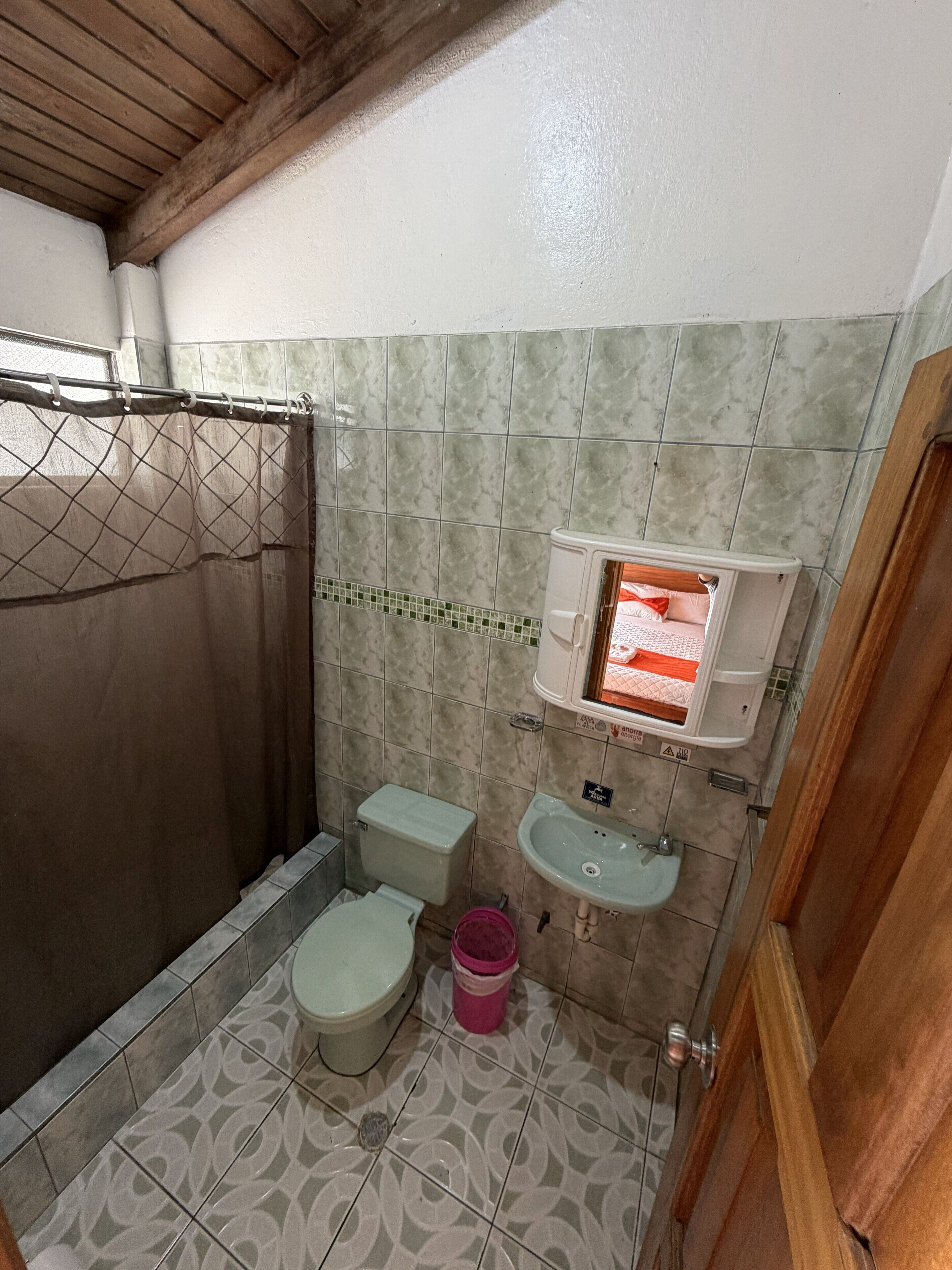 A bathroom with a shower, toilet, and sink.