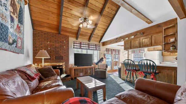Una sala de estar acogedora con sofás de cuero, una chimenea y un televisor.