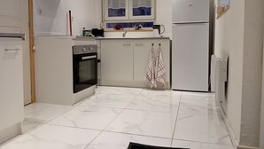 A compact kitchen with a built-in oven, a microwave, and a refrigerator. - Apartment 44 m2 Located in a quiet village.  Shops nearby. (Kesseldorf)
