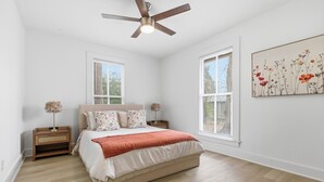 A bedroom with a bed, nightstands, a ceiling fan, and a window with blinds. - Charming 2BR Retreat in North Little Rock, Close to Hospitals & Downtown (North Little Rock)