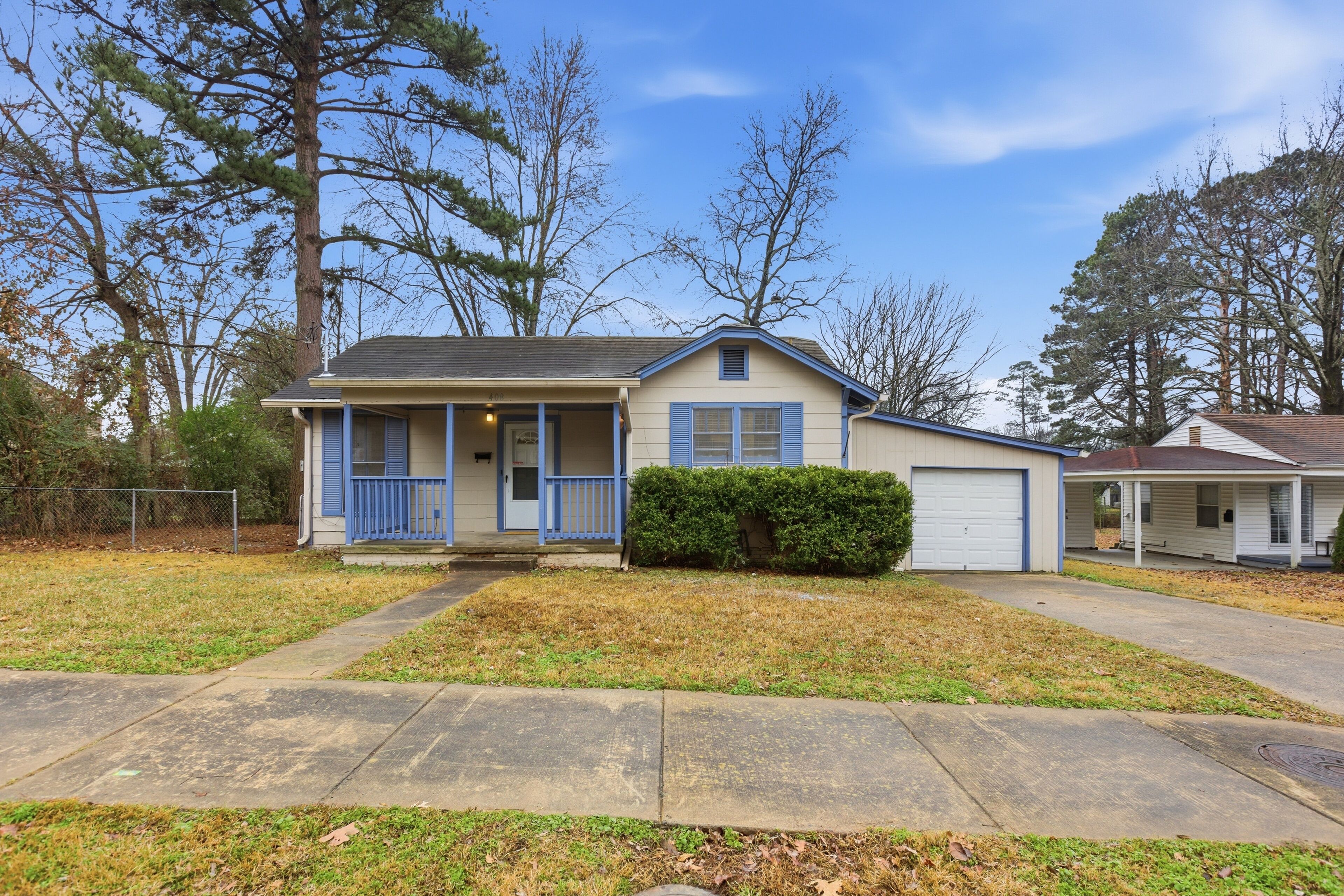 A single-story house with a front porch, a garage, and a well-maintained lawn.