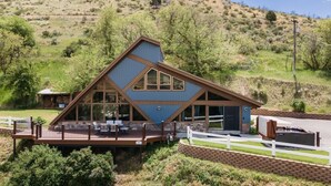 Ein modernes Bergharfen mit Terrasse, großen Fenstern und Garage.