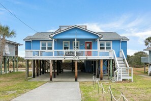 Ein blaues Haus mit roter Tür und einer Veranda.