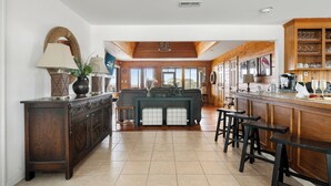 Una cocina amplia con una isla de madera, taburetes de bar y vistas al exterior.