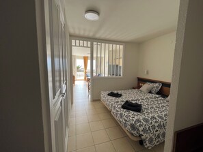 A bedroom with a bed, a window, and a view of the balcony. - Palm Garden Apartment with terrace, amazing ocean view and swimming pool. (Morro Jable)