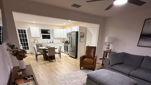 Moderni olohuone, jossa on harmaa sohva, ruskea nahkainen nojatuoli ja puinen sohvapöytä.