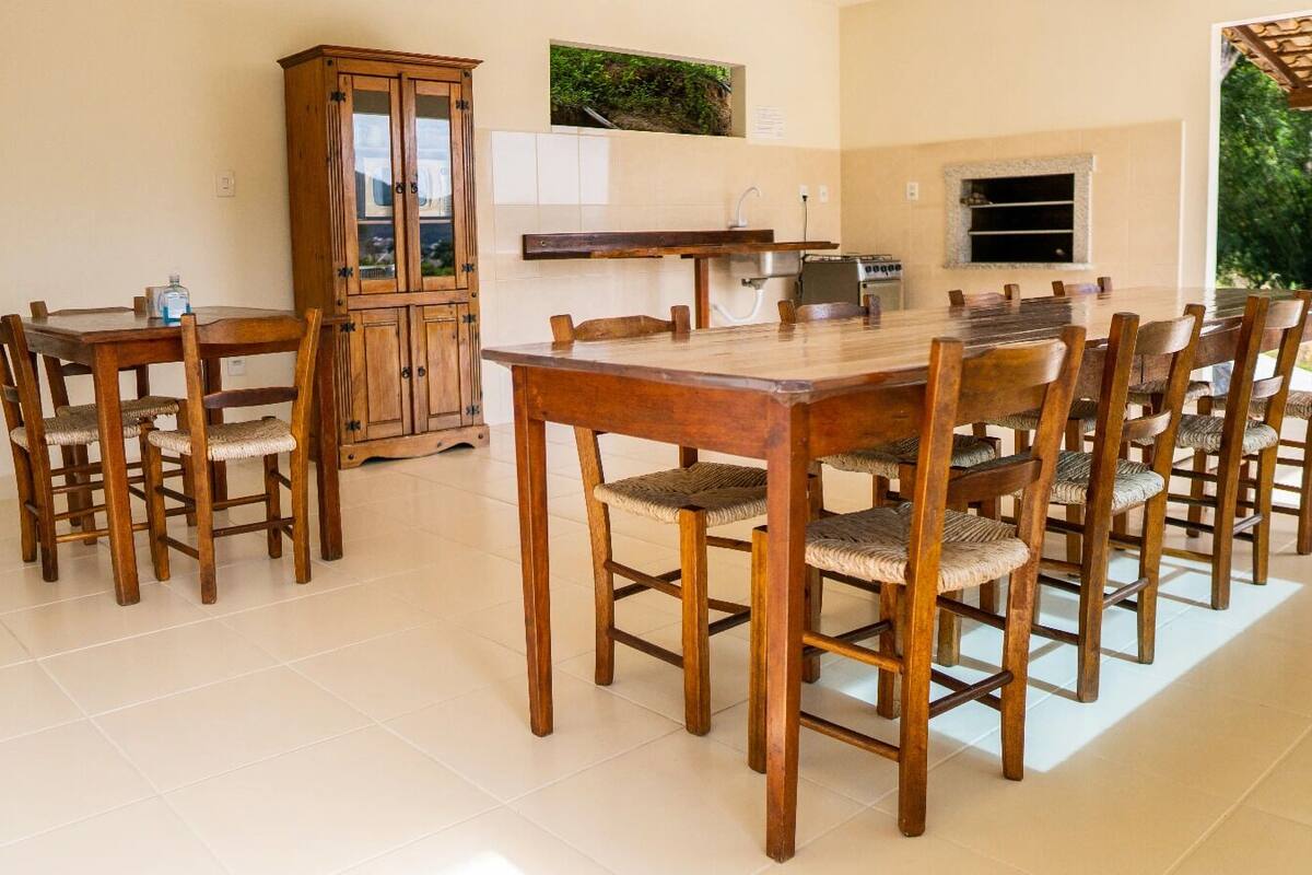 Un coin repas avec une table et des chaises en bois, un buffet et un espace cuisine comprenant une cuisinière et un évier.