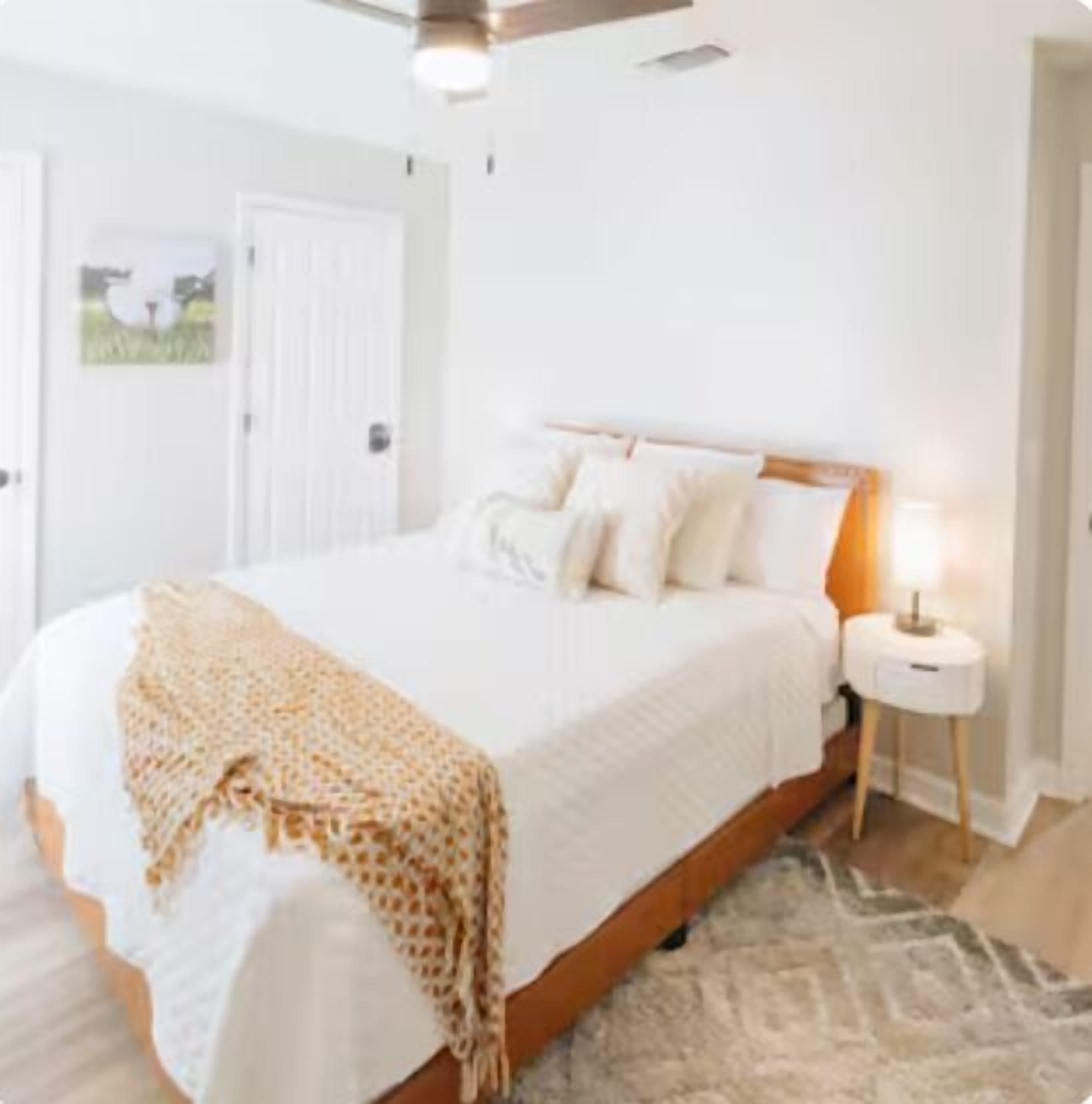 Une chambre à coucher avec un lit, une table de chevet et une porte.