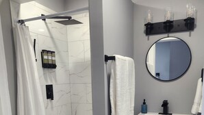 Une salle de bain moderne équipée d’une douche, de toilettes et d’un lavabo.