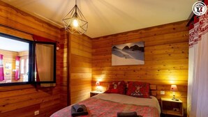 Een gezellig houten kamer met een bed, een raam en een schilderij aan de muur.