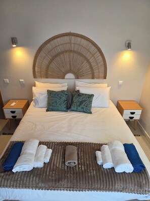 A neatly made bed with pillows, a headboard, and a bedside table with a lamp. - Casa Elizabeth: 3BR Heatable Pool, Walk to Beach (Carvoeiro)