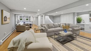 Ein modernes Wohnzimmer mit Sofa, Couchtisch und Blick in die Küche.